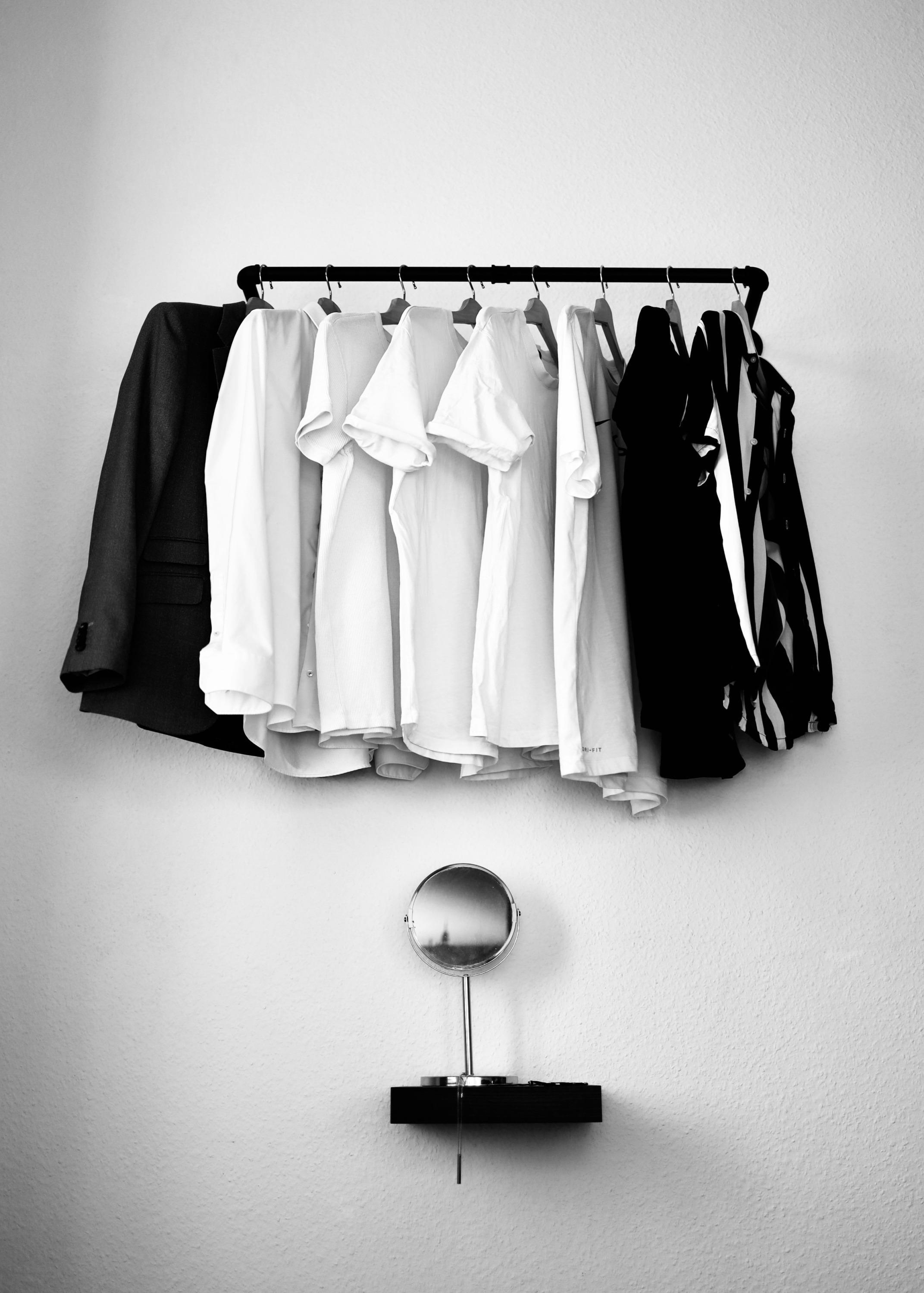 Black and white image of shirts hung in a closet before being packed in a box to move
